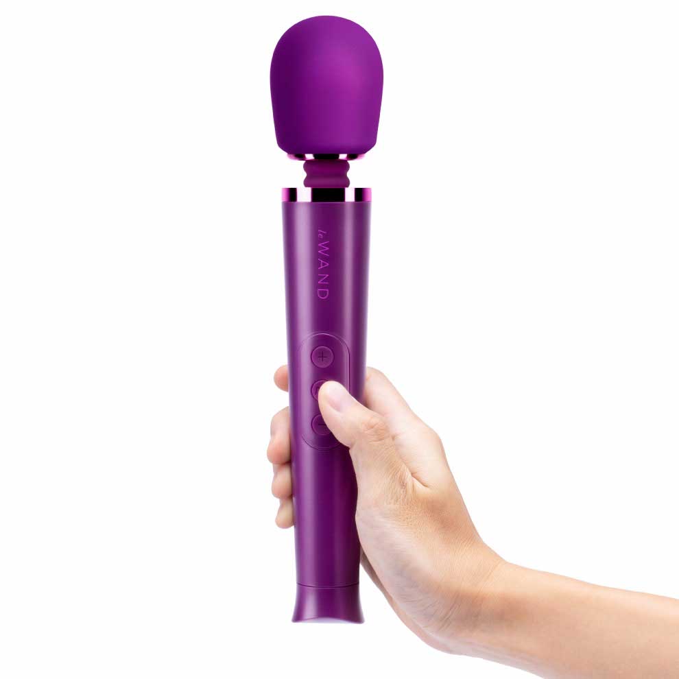 person holding the le wand petite rechargeable massager lw-007chr dark cherry